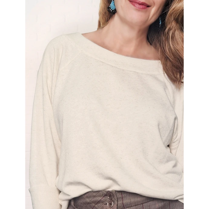 Detalhe de mulher posando com mãos na cintura usando blusa manga raglan em moletinho cru natural