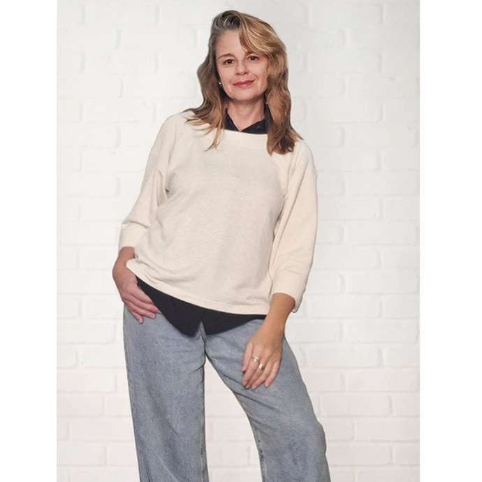 mulher posando com mãos na cintura usando blusa manga raglan em moletinho cru natural com calça jeans